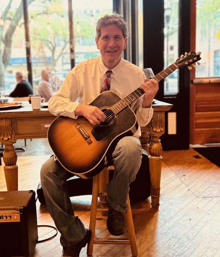 Eddie Cook holding guitar at Bistro 214 in Shelby, NC